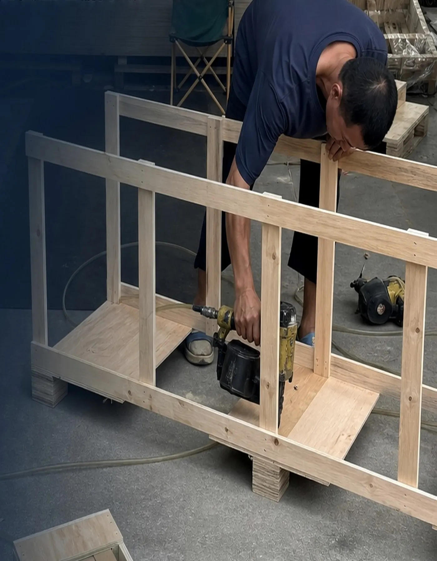 Worker building custom wooden protection for furniture and building-material cargo